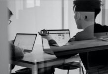 Why You Should Invest in Professional Services Automation Two people sitting with laptops at a table discussing professional services automation